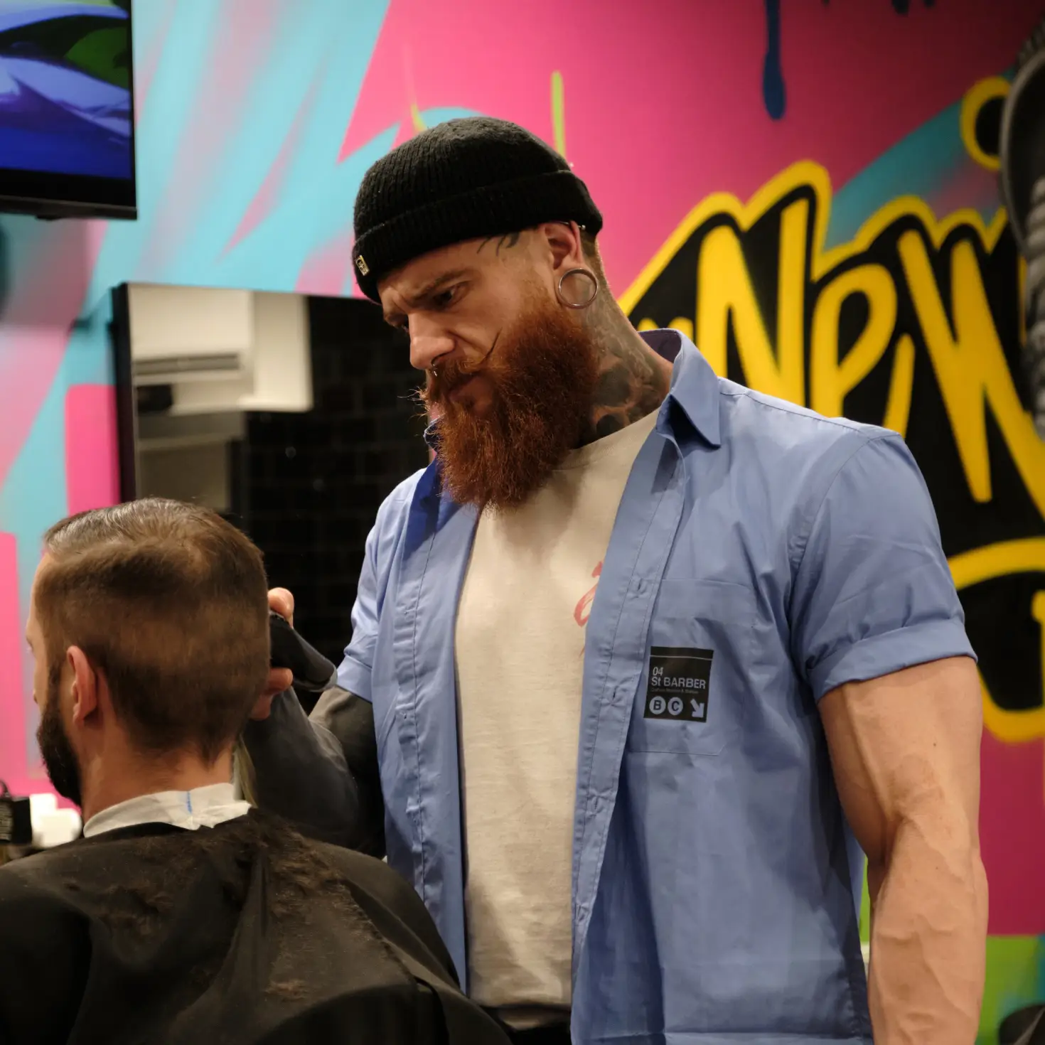 Kylian, barbier chez 04 ST BARBER Béziers, en pleine coupe dans un décor urbain