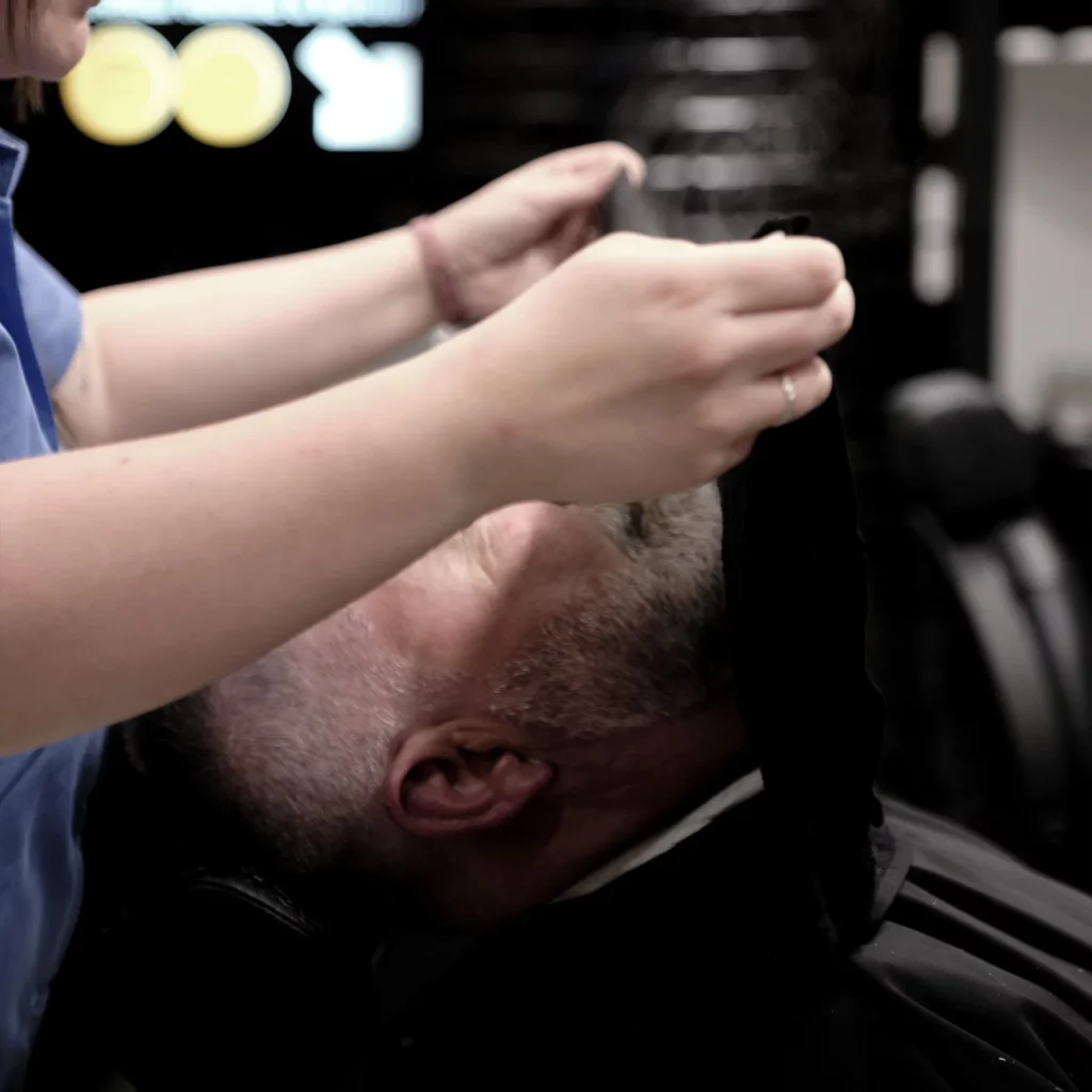 Application d’une serviette chaude avant rasage au salon 04 St BARBER Béziers