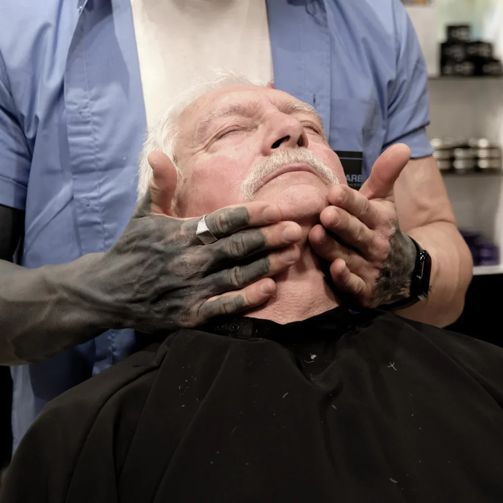 Massage du visage d’un client senior après une prestation