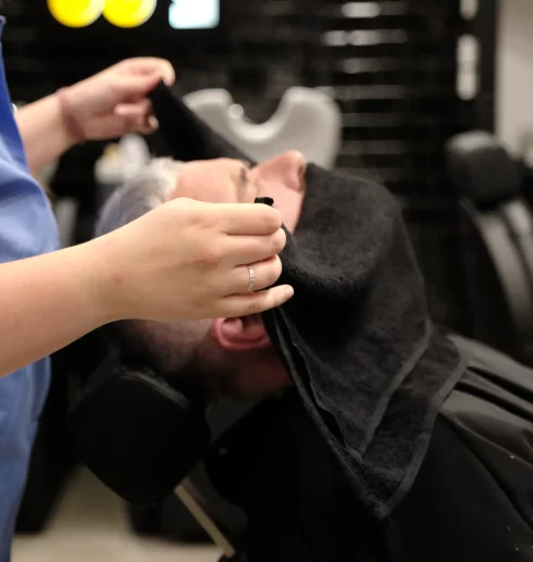 Serviette chaude appliquée pendant un soin barbe chez 04 ST BARBER Béziers